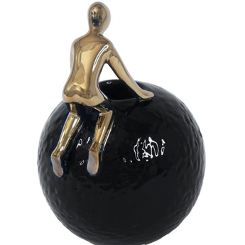 Man Crawling on Ball Sculpture